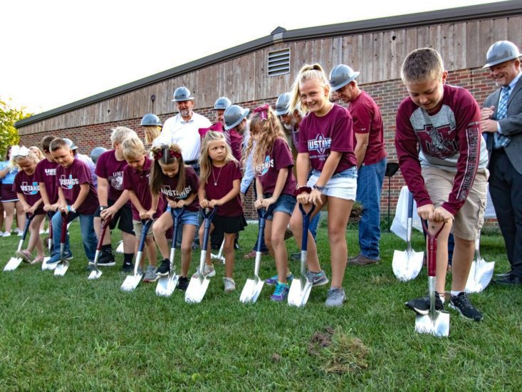 Children with shovels breaking ground