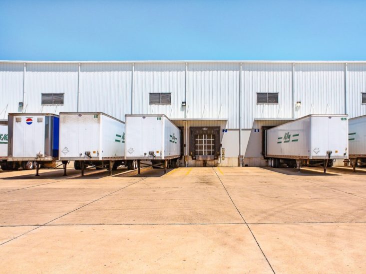 Industrial dock with multiple trucks at bottling plant