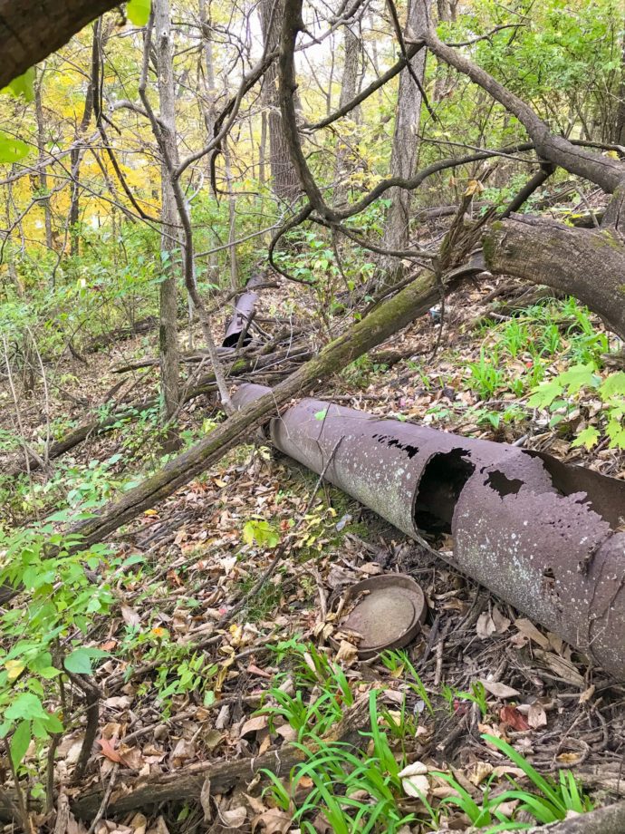 Deteriorated storm sewer piping across a wooded area