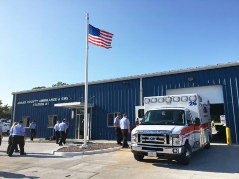 An ambulance sitting in an open bay of the facility with EMS personnel