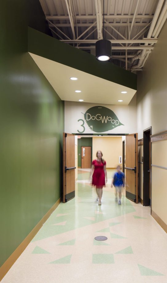 A third grade classroom pod entrance with a teacher and student walking.