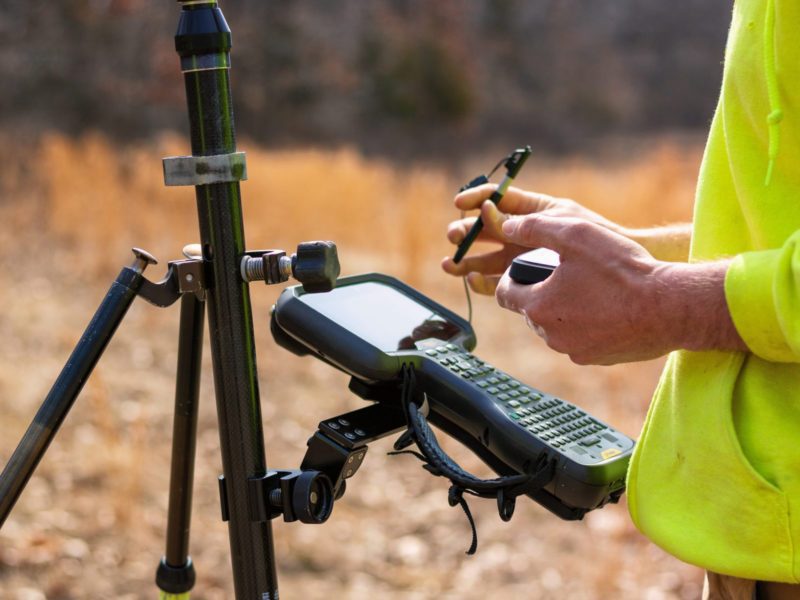 A surveyor typing on a controller