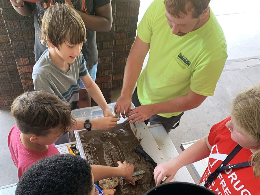 A Klingner employee teaching children about erosion at a stream table