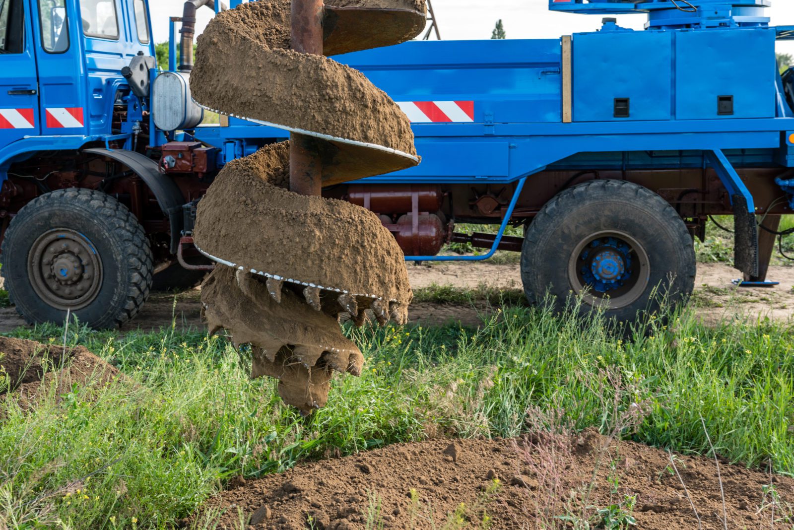 Tracer tractor with auger for soil drilling for piles