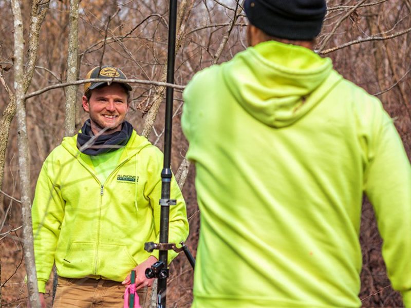 A surveyor smiling as he works on a jobsite